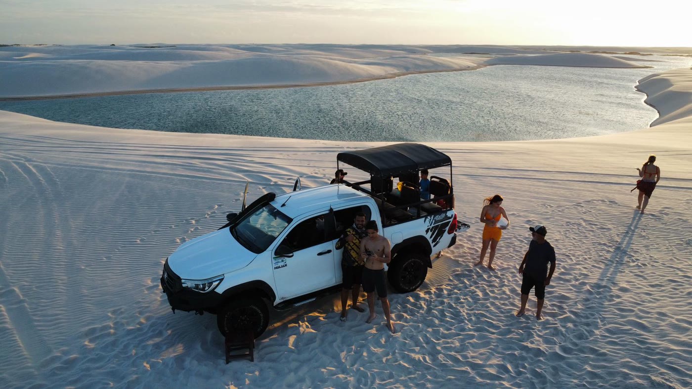 Jardineira 4x4 parada nas dunas com turistas