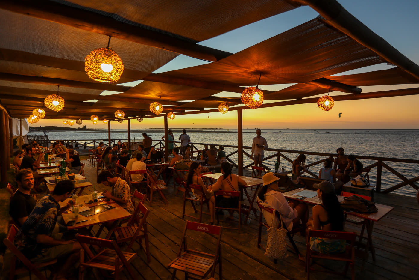 Restaurante com deck de madeira à beira da água no fim da tarde