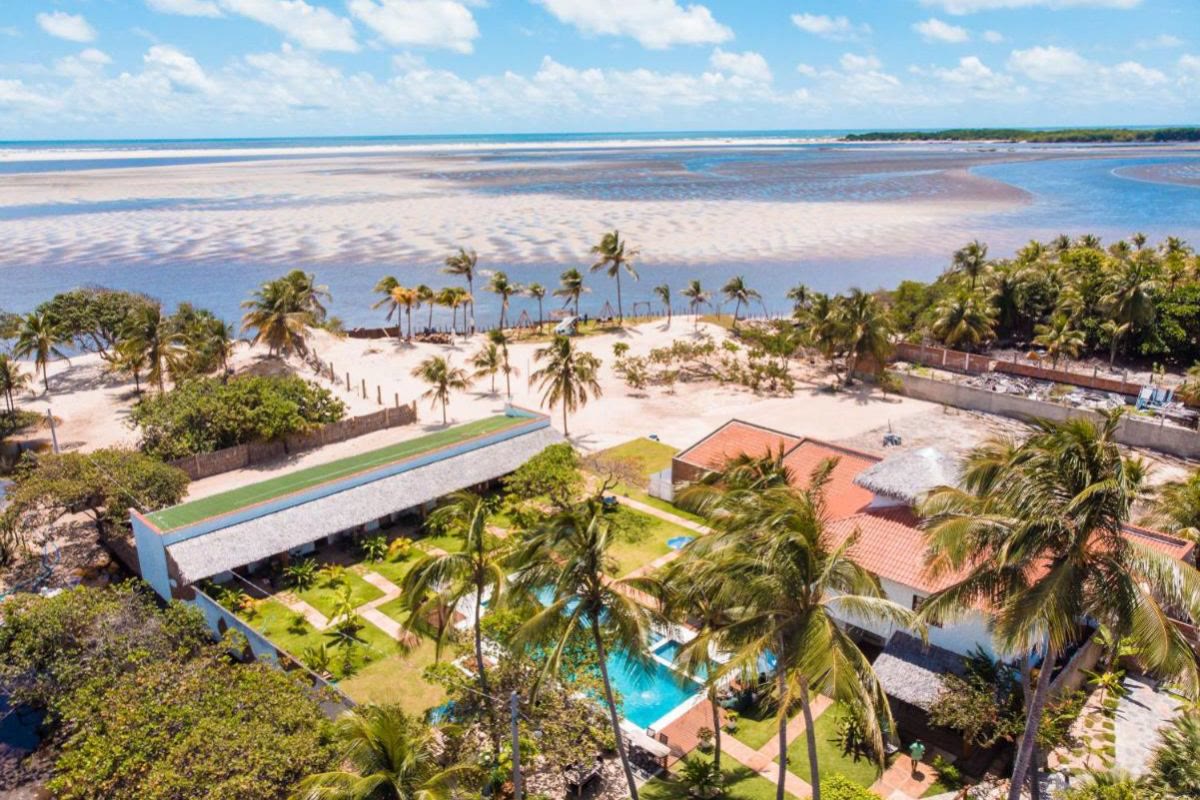 Vista aérea de pousada com coqueiros perto da praia em Atins