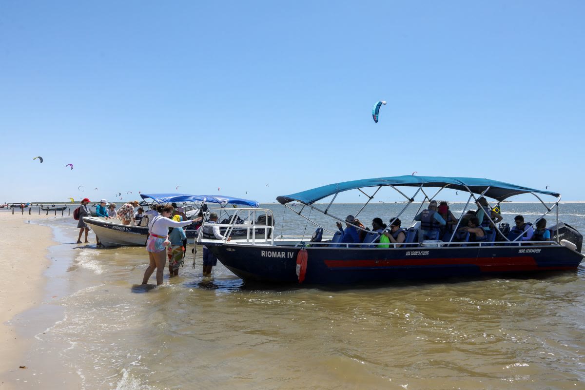 Lancha na beira do rio com turistas desembarcando